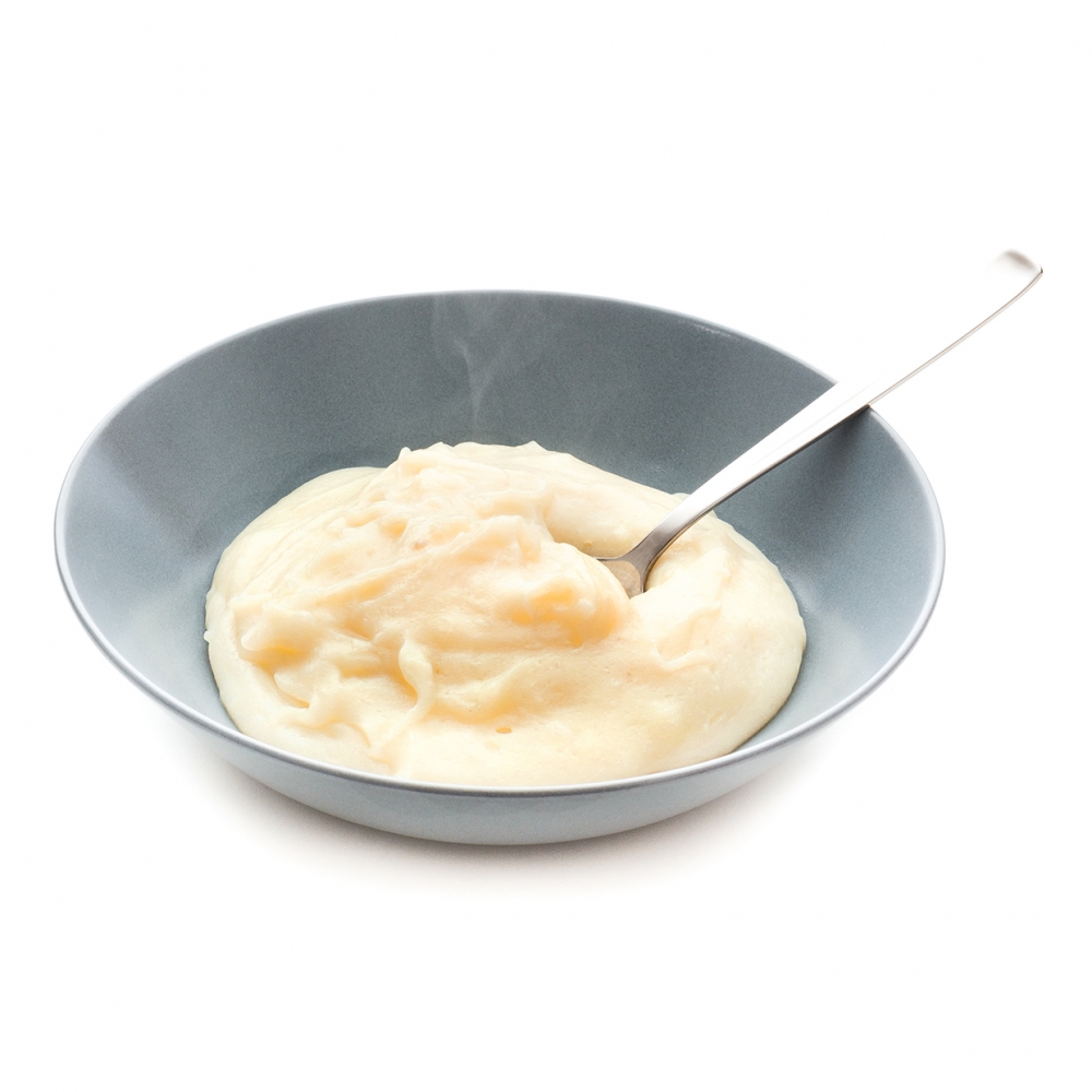 Imagen en la que se ve un plato de puré de patata con una cuchara dentro