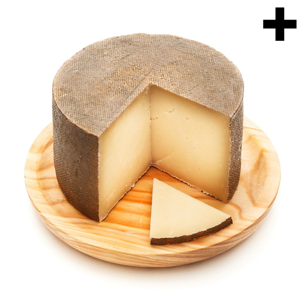 Imagen en la que se ve un queso al que le falta un cuarto. Delante de él hay una loncha de queso.