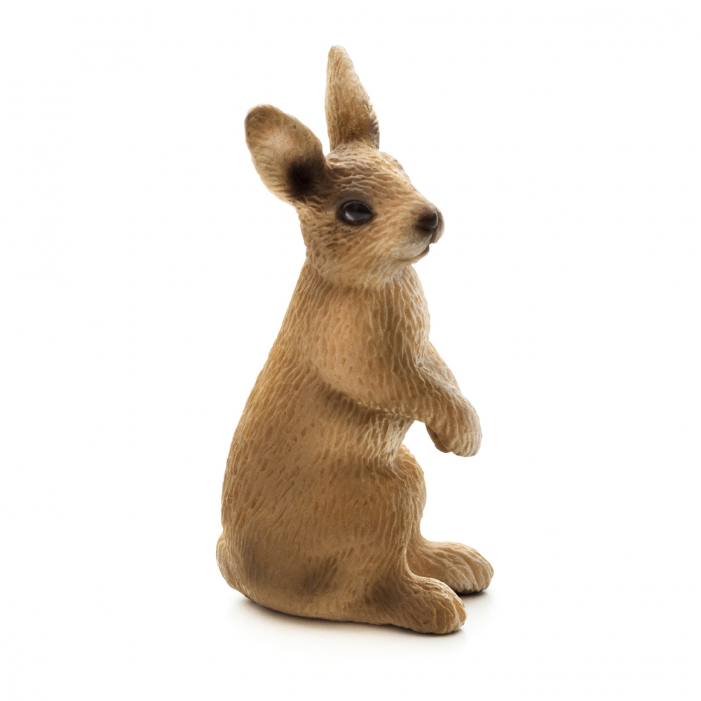 Imagen en la que se ve un conejo sentado sobre sus patas traseras de perfil