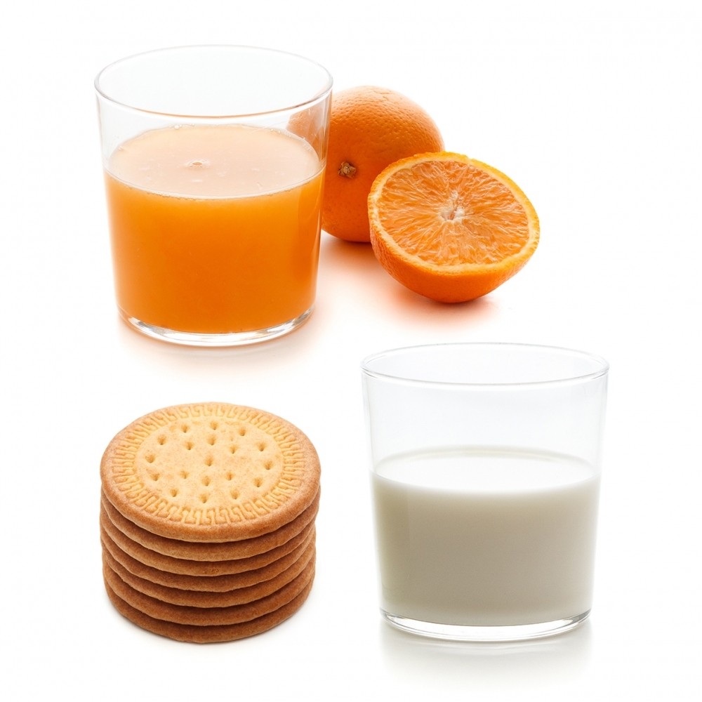 Imagen en la que se ven tres alimentos que se toman en el desayuno: galletas, leche y zumo de naranja