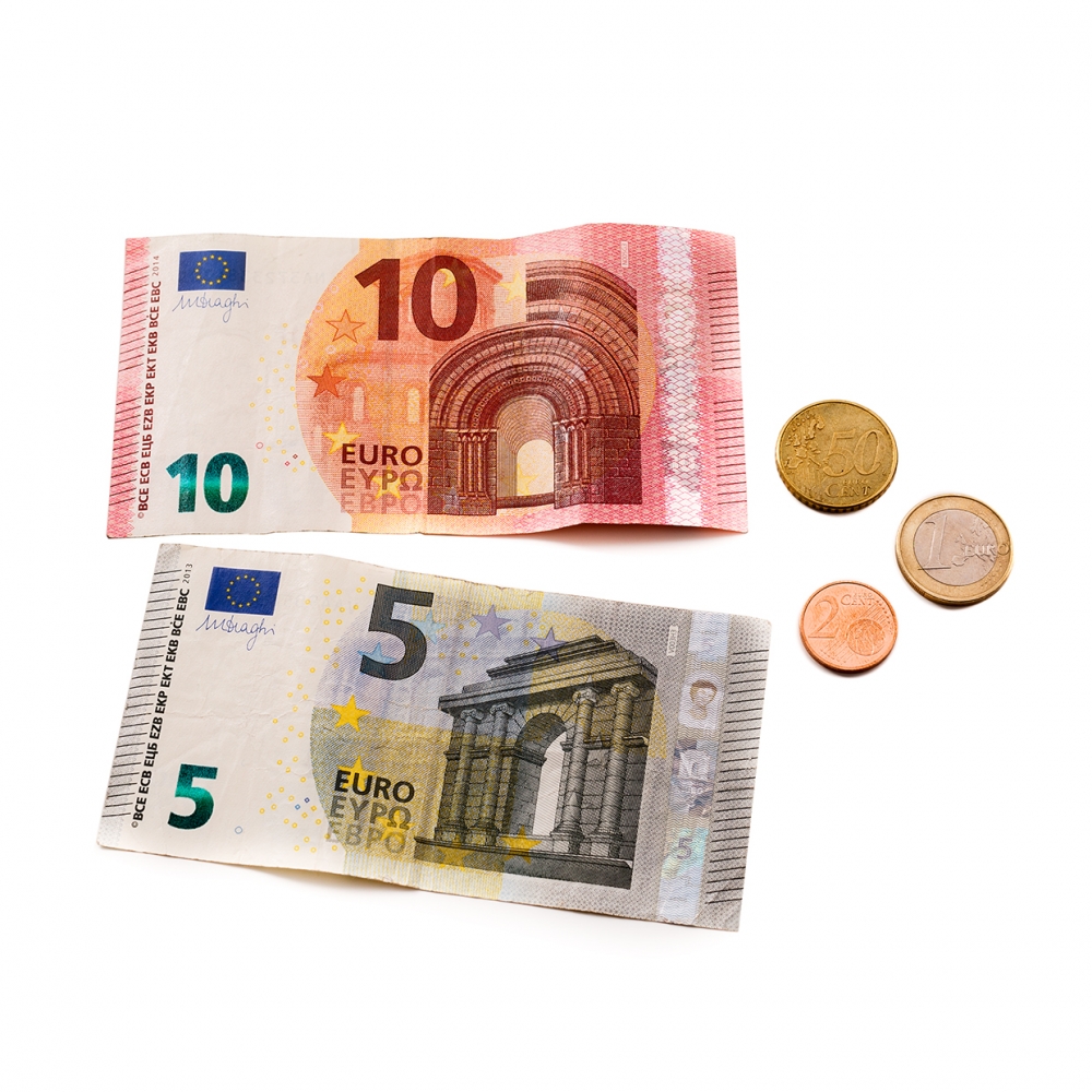 Imagen en la que se ven dos billetes y tres monedas