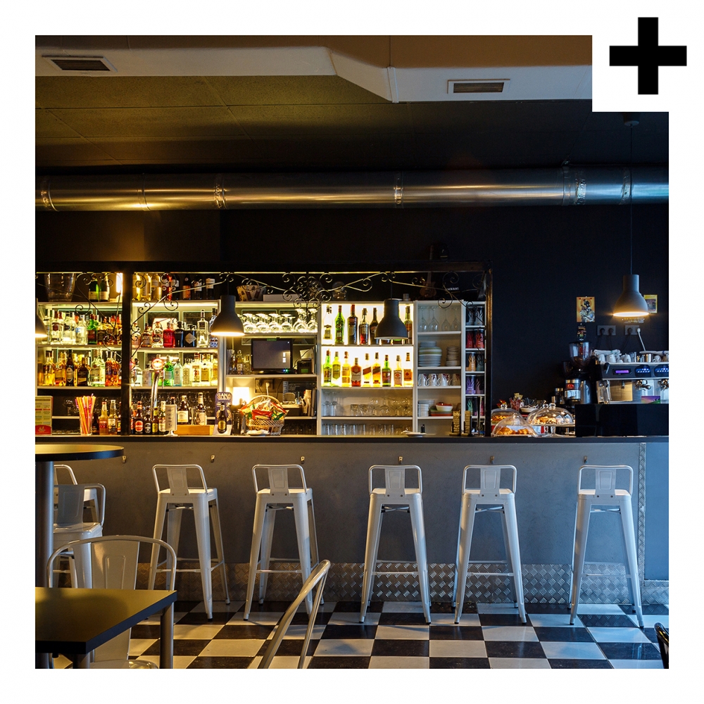 Imagen en la que se ve una barra de bar con banquetas delante