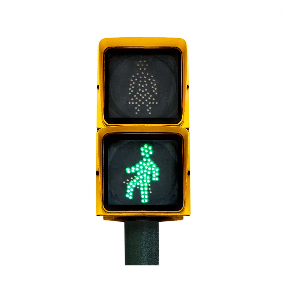 Imagen en la que se ve un semáforo de peatones con la luz verde iluminada