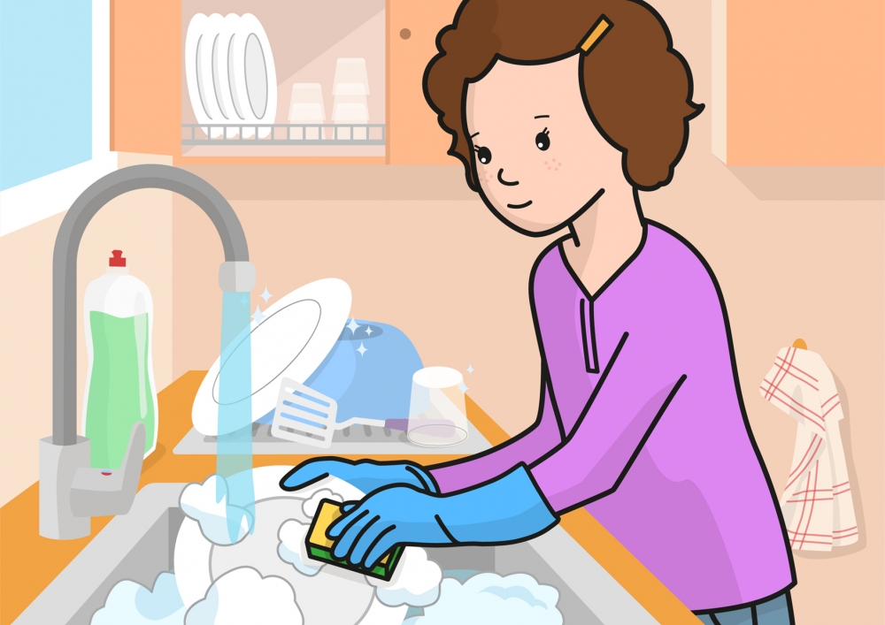 La niña friega los platos con agua y jabón