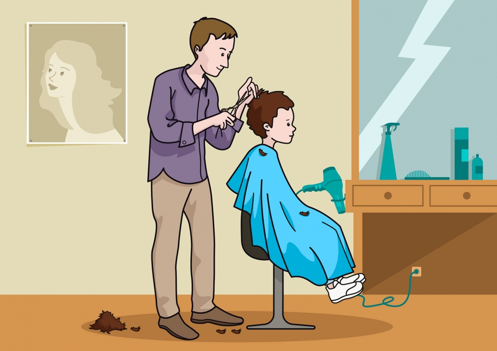 El peluquero corta el pelo al niño
