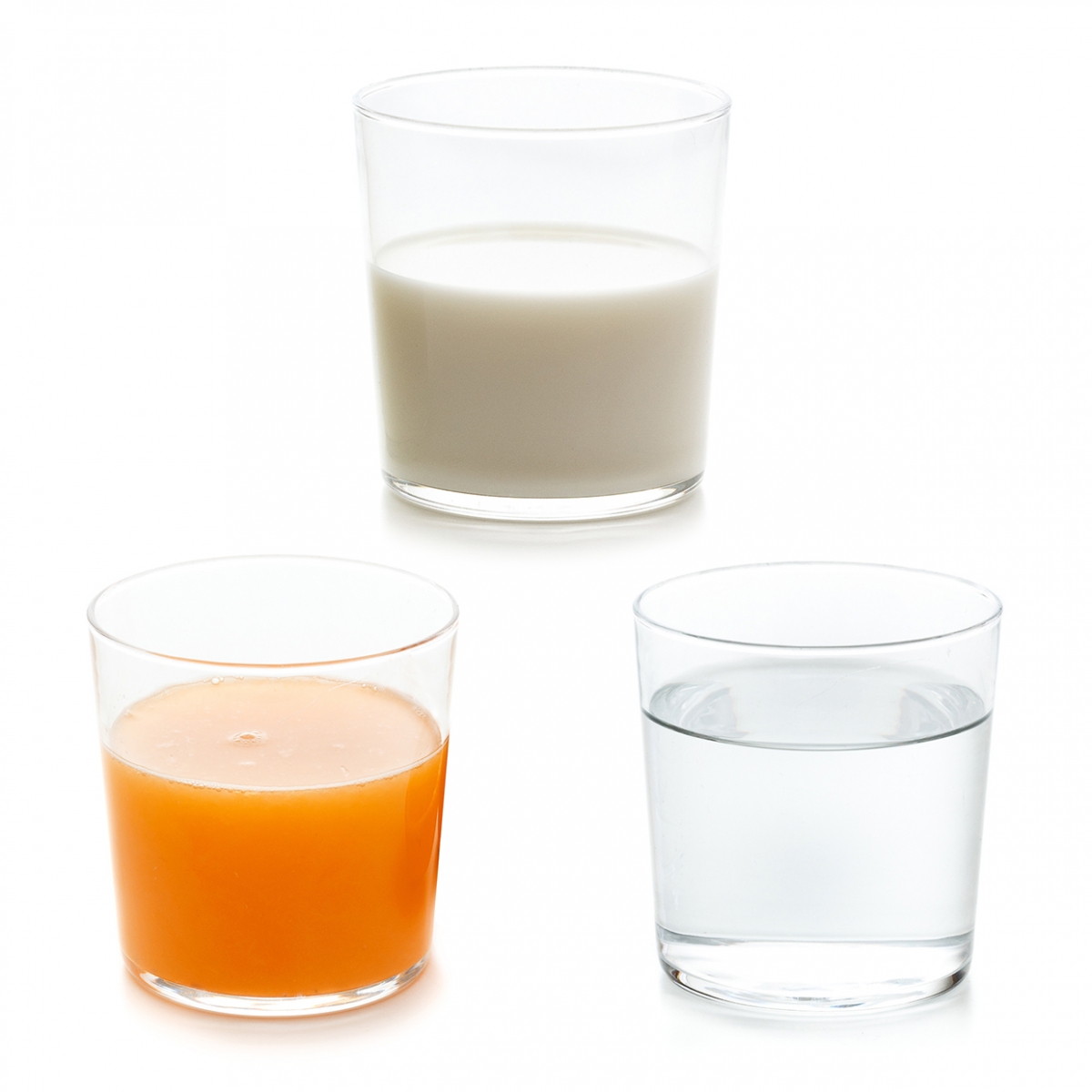 Imagen en la que se ven tres bebidas: un vaso de zumo, un vaso de agua y un vaso de leche