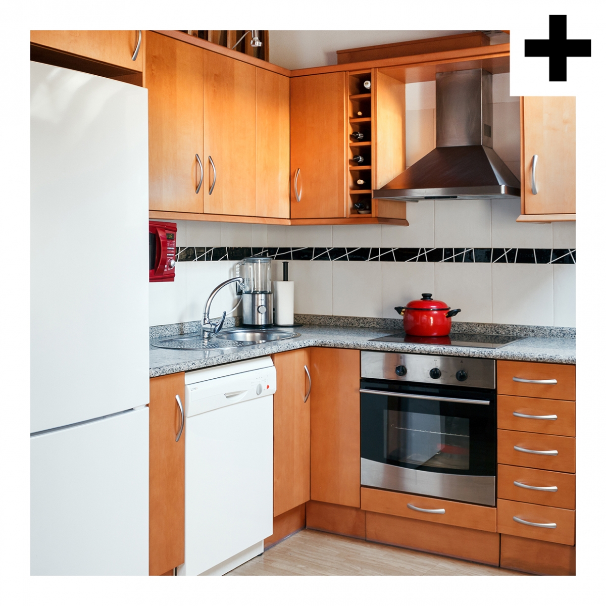 Imagen en la que se ve una cocina compuesta de frigorífico, lavavajillas, campana, horno, fregadero y placa vitrocerámica