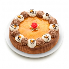 Imagen en la que se ve una tarta entera rematada por nata, trufa y una flor