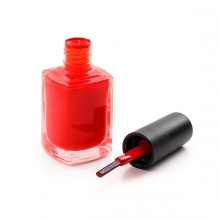 Imagen en la que se ve un frasco de esmalte de uñas de color rojo