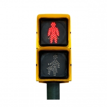 Imagen en la que se ve un semáforo de peatones con la luz roja iluminada